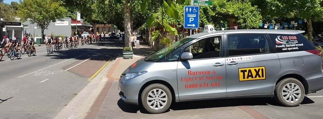 Barossa & Light Cab Service taxi in Tanunda with Tour Down Under cyclists racing through town