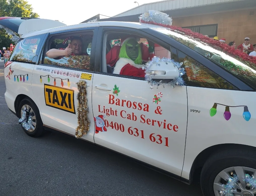 The Grinch riding in Barossa & Light Cab Service taxi during Tanunda Christmas Parade