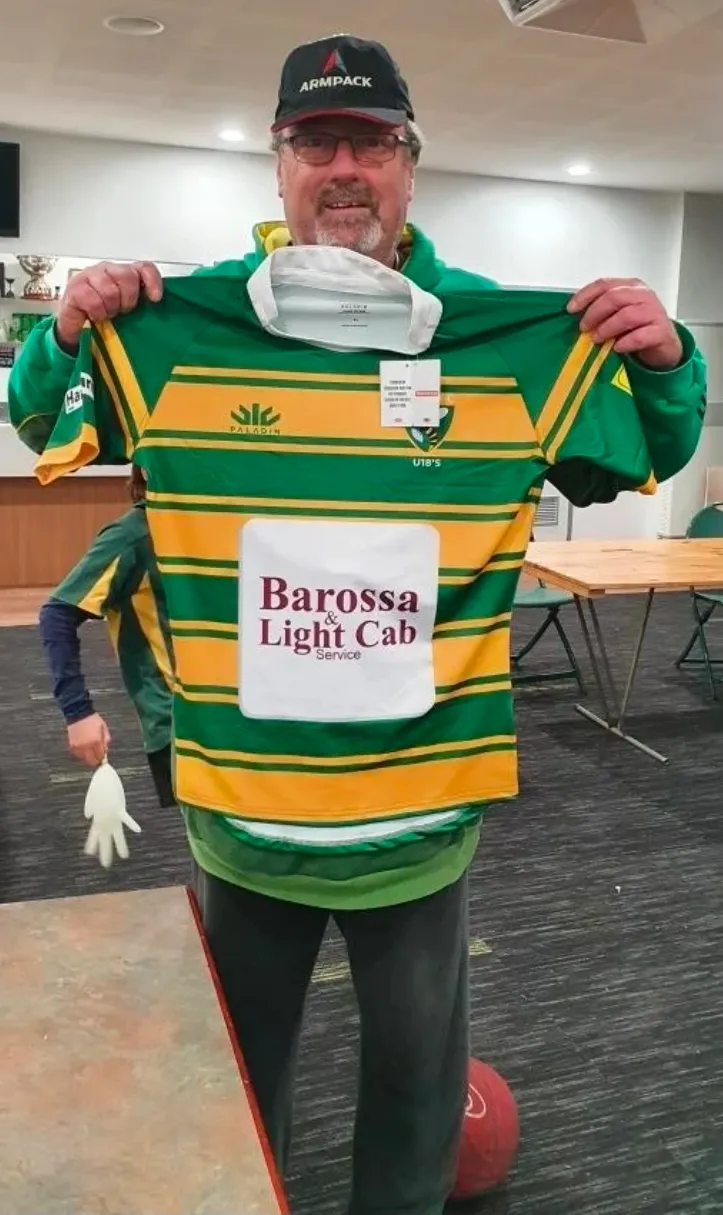 Craig holding Barossa & Light Cab Service sponsored rugby jersey